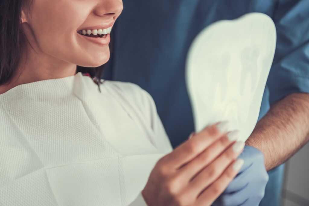 Woman at dentist's office looking at her reflection in the mirror.